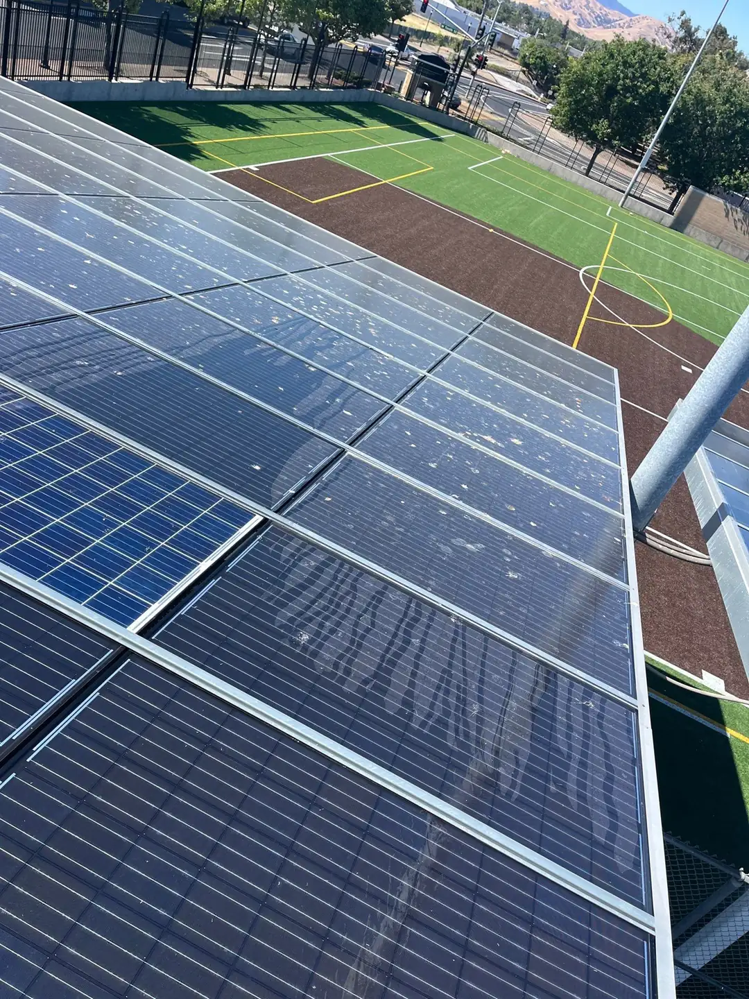 Heavily soiled solar carport modules with bird droppings and dust before cleaning, school site, Pittsburg CA